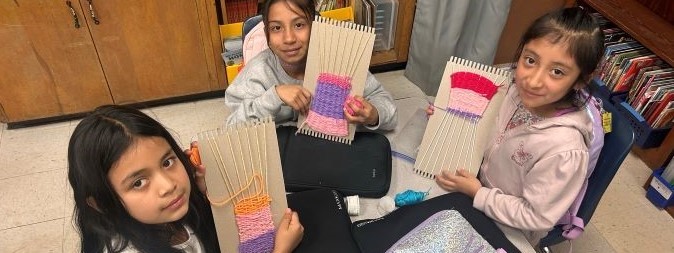 students learning to weave